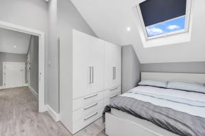 um quarto branco com uma cama e uma janela em Your Cosy Stay Modern 2 Double Bedroom Flat Fully Furnished - 5 Mins walk to Stn em Londres