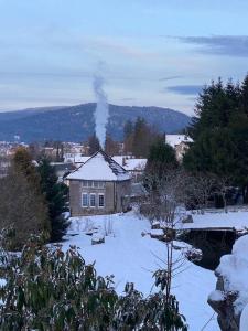 una casa con humo saliendo de ella en la nieve en Villa sans soucis, en Gérardmer