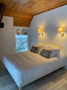 1 dormitorio con 1 cama blanca grande y 2 almohadas en Villa sans soucis, en Gérardmer