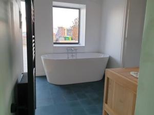 Una bañera blanca en un baño con ventana. en LODGE bennouri, en Telouet 31 fotos más