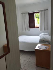 a small bedroom with a bed and a window at Apartamento na Frente da Praia in Itanhaém