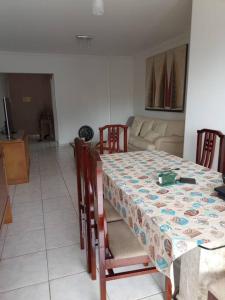 a table and chairs with a table and a couch at Apartamento na Frente da Praia in Itanhaém +20 photos