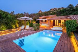 una piscina en un patio trasero con una casa en Costa Paradiso Resort en Costa Paradiso