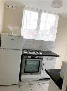 a kitchen with a stove and a white refrigerator at Ac lounge 115 1-Bed Apartment in Rochford in Rochford