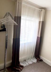 a bedroom with a window with curtains at Ac lounge 115 1-Bed Apartment in Rochford in Rochford