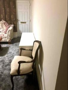 Zimmer mit Stuhl, Tisch und Tür in der Unterkunft Ac lounge 115 1-Bed Apartment in Rochford in Rochford