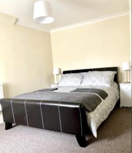 a bedroom with a large bed with a black headboard at Ac lounge 115 1-Bed Apartment in Rochford in Rochford