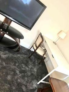Ac lounge 115 1-Bed Apartment in Rochford في روتشفورد: غرفة بها كرسي وتلفزيون بشاشة مسطحة