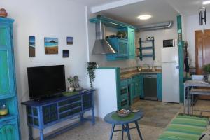 a kitchen with blue cabinets and a tv on a table at Vistas al Mar Mediterraneo in Melicena