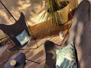 two black chairs with pillows sitting on a deck at LES BOHEMIELLES Chambre Mathilda in Cartelègue