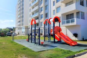 a playground in front of a building with a slide at Condominio Pacífico 2800 in La Serena