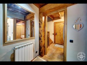 a hallway of a house with a mirror and a radiator at CASA SAUTARETH de Alma de Nieve in Tredós