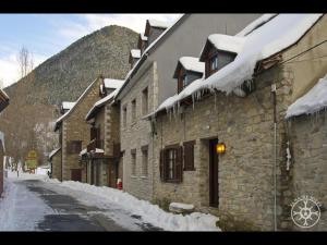 a snow covered street in a town with buildings at CASA SAUTARETH de Alma de Nieve in Tredós