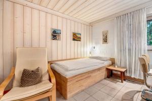 a small bedroom with a bed and a chair at Haus Erna am Deister Apartment in Barsinghausen