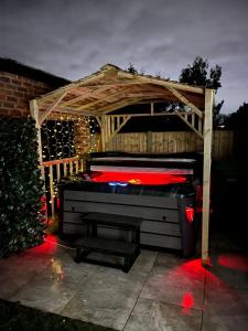 - un lit dans un kiosque en bois avec des lumières rouges dans l'établissement Balmoral House, à Timperley