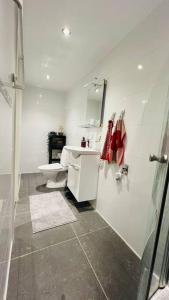 Baño blanco con aseo y lavamanos en Newly built amazing apartment, en Järfälla