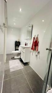 a white bathroom with a toilet and a sink at Newly built amazing apartment in Järfälla