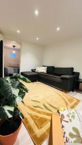 a living room with a couch and a plant at Newly built amazing apartment in Järfälla