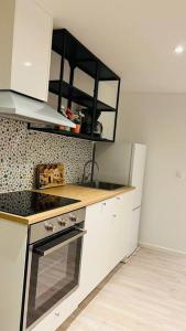 cocina con fregadero y fogones horno superior en Newly built amazing apartment, en Järfälla