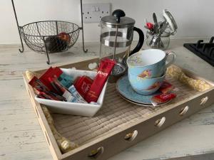 a wooden tray with a cup and a coffee mug at Beautiful 1 bed annex, near beach and shops in Iford