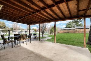 a covered patio with a table and chairs and a field at Centrally Located Little Gem in San Antonio
