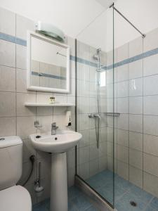 a bathroom with a sink and a glass shower at Konstantina Apartments in Kavos