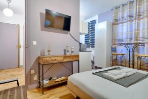 a bedroom with a bed and a tv on the wall at Agréable studio proche Paris et Porte de Versailles in Malakoff