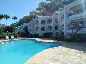 a large white building with a large swimming pool at Tropical Optimal Tropicana Sur in Sosúa