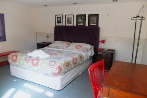 sypialnia z łóżkiem z czerwonym krzesłem i stołem w obiekcie Casa San Telmo 3030 w BuenosAires
