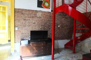 salon z telewizorem i czerwonymi schodami w obiekcie Casa San Telmo 3030 w BuenosAires