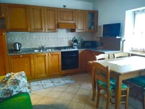 a kitchen with wooden cabinets and a table with a sink at Appartamento Daniela Dolomiti. in Auronzo di Cadore +10 photos