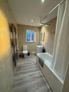 a bathroom with a tub and a toilet and a sink at Beautiful two bed home in Marsh in Lindley