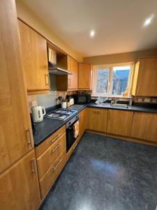 cocina con armarios de madera y horno con fogones en Beautiful two bed home in Marsh en Lindley