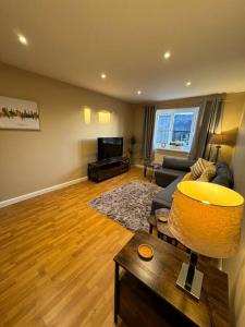 a living room with a couch and a tv at Beautiful two bed home in Marsh in Lindley