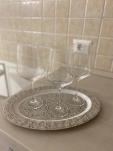 tres copas de vino en un plato en un mostrador en Marinai Home, en Catania