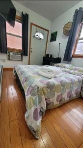 a bedroom with a bed and a wooden floor at comfortable room with balcony near the train in Woodside