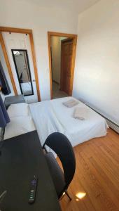 a room with a bed and a desk with a chair at comfortable room with balcony near the train in Woodside