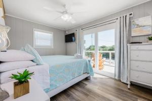 um quarto com uma cama e uma varanda em The Blue Bungalow St. George Island em St. George Island