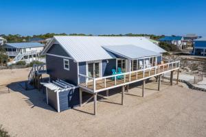 una casa azul en una playa con terraza en The Blue Bungalow St. George Island en St. George Island