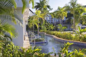 a resort pool with palm trees and a building at Royalton Hideaway Blue Waters - Montego Bay, An Autograph Collection All-Inclusive Resort - Adults Only in Falmouth