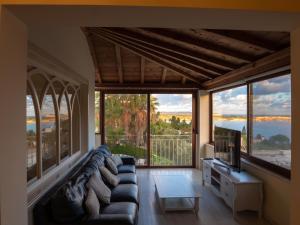 - un salon avec un canapé et une télévision dans l'établissement Villa Alexandra - Sunset Sea Views, Heated Jacuzzi, Sauna and Gym, à Mellieħa