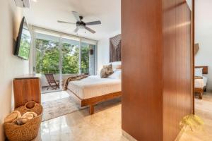 un dormitorio con una cama y una ventana en NHOA 211B Lux 1BR Condo Pool View in Aldea Zama, en Tulum 63 fotos más
