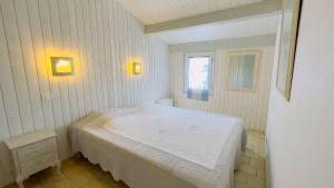 Un dormitorio con una cama blanca en una habitación. en Location proche de la plage et des commerces, en La Couarde-sur-Mer 8 fotos más