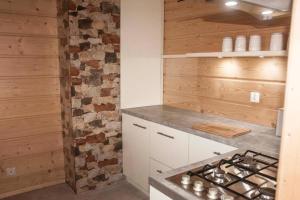 a kitchen with wooden walls and a stove top oven at Domek na Zawojskim Przysłopiu in Zawoja
