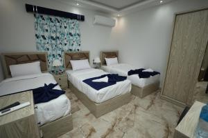 a bedroom with two beds with blue sheets at Capital Of Pyramids Hotel in Cairo