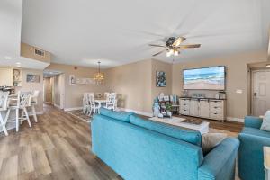 a living room and dining room with a blue couch at Oceanwalk 1-401 in New Smyrna Beach