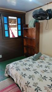 a bedroom with a bed and a window at Pousada Sobre as Ondas - ILHA DO MEL - PR in Ilha do Mel