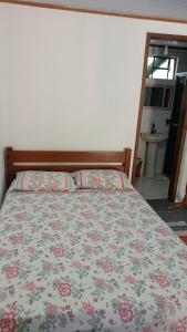a bedroom with a bed with a floral bedspread at Pousada Sobre as Ondas - ILHA DO MEL - PR in Ilha do Mel