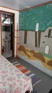 a bedroom with a bed and a painting on the wall at Pousada Sobre as Ondas - ILHA DO MEL - PR in Ilha do Mel