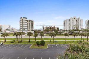 a parking lot with palm trees and tall buildings at Oceanwalk 1-401 in New Smyrna Beach